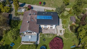 Luchtbeeld van een woonhuis met een groot huis, een zwembad en een keurig onderhouden tuin.