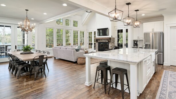 A spacious kitchen with a large island, white cabinetry, and modern appliances.