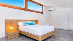 Ein Schlafzimmer mit einem hölzernen Bett, Nachttischen, einem Fenster und einem Kleiderschrank.