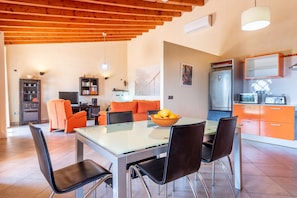 A modern kitchen with a refrigerator, microwave, and orange cabinets. - Mediterranean Finca "Es Puch" with Mountain view, Balcony, Garden, Terrace & Pool (BUGER)