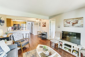 Relax in a comfortable living space with a sofa, armchairs, and flat-screen TV.