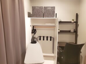 Bathroom features a white vanity with a mirror, a black chair, and a towel rack.