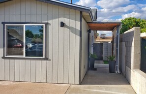 Stroll through the serene garden, surrounded by lush greenery, to the entrance of this stylish home.