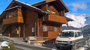 A wooden chalet with a balcony, a staircase, and a van parked in front. - Adlerhorst by Interhome (Adelboden)