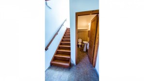 Staircase leads to a bathroom with a sink and toilet.