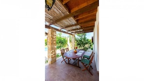 Relax in this serene outdoor space surrounded by lush greenery and a sparkling pool.