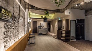 Un interior moderno con mostrador de recepción, suelo de madera y pared de piedra.