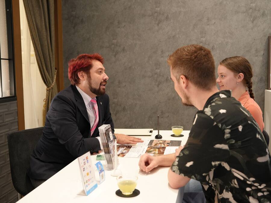 Ein Konferenzraum mit einem weißen Tisch, Dokumenten und einer kleinen Tischlampe.