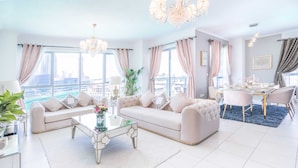 A spacious living room with two sofas, a coffee table, and a dining area with a table and chairs. - Elite Royal Apartment - Burj Khalifa & Fountain view - Opal (Dubai)