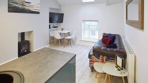 A modern living space with a loft bedroom, a dining area, and a cozy seating area.