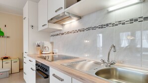 A modern kitchen with white cabinets, a stainless steel sink, and a built-in oven. - Quaint Apartment in Hainzenberg near Horbergbahn (Hainzenberg)