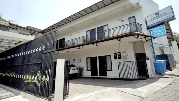 A modern building with a gated entrance, a balcony, and a sign indicating a business or office space. - D’Paragon Tambakboyo (Depok)