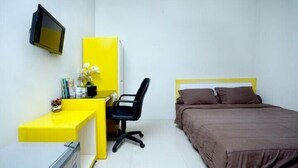 A bedroom with a bed, a desk, a chair, and a television. - D’Paragon Tambakboyo (Depok)