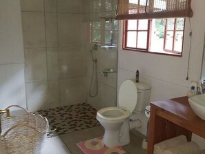 A bathroom with a toilet, shower, and sink. - Mar Azul 14 (Ponta d'Ouro)