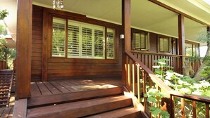 Eine hölzerne Veranda mit einer Treppe zu einem überdachten Bereich.