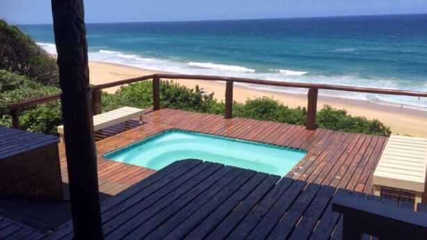 A wooden deck with a pool overlooking a beach and ocean. - Mar Azul 1B (Ponta d'Ouro)