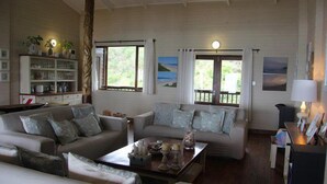 A living room with two sofas, a coffee table, and a bookshelf. - Mar Azul 1B (Ponta d'Ouro)