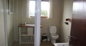 Un bagno piccolo e funzionale, con il water, un lavandino e una finestra.