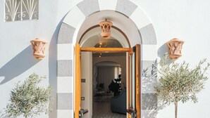 A doorway with an arched entrance, a wooden door, and two wall-mounted lanterns. - Hotel Zì 'Ntonio (Scala)