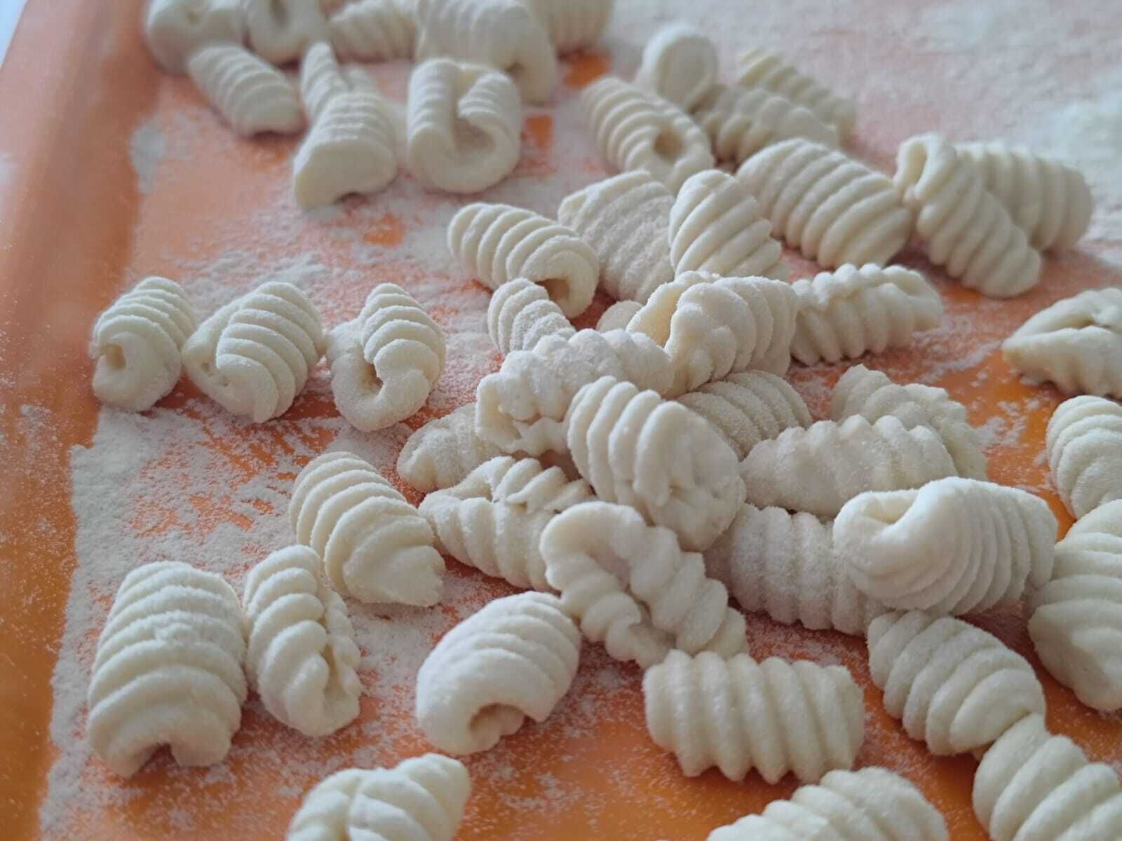 A tray of freshly made pasta dough on a floured surface.