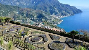A coastal landscape with terraced gardens, a mountain range, and a view of the sea. - Hotel Zì 'Ntonio (Scala)