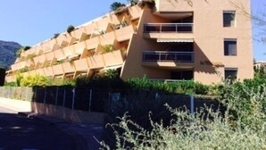 Un immeuble à plusieurs étages doté d’une façade géométrique originale, de balcons et d’un toit plat.