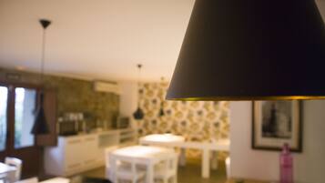 A blurred interior of a room with a dining table, chairs, and a hanging lamp.