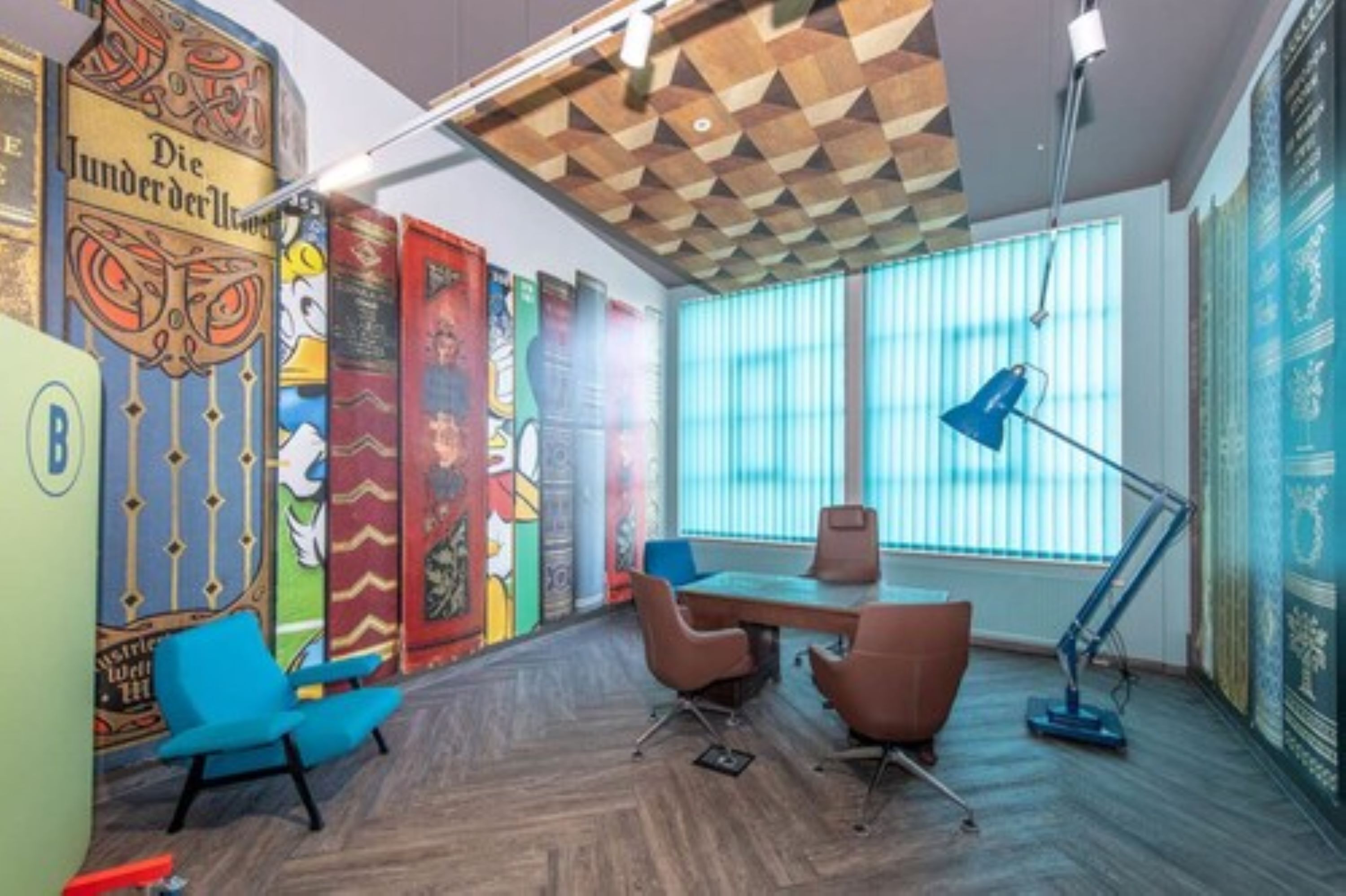 A modern office with a wooden ceiling, colorful murals, a large window with blinds, and a desk with chairs.