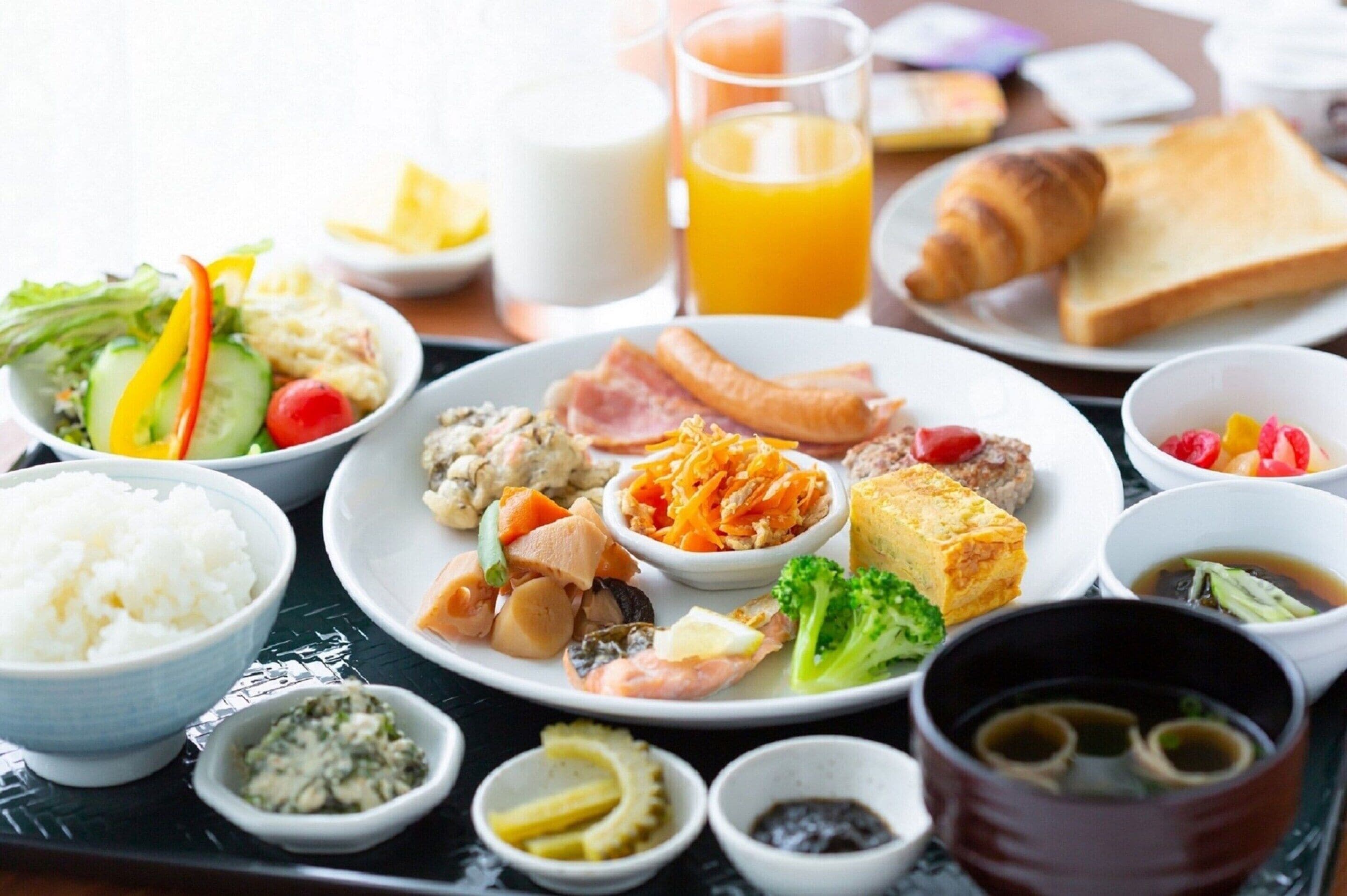 Ein Frühstücksbrett mit verschiedenen Speisen, darunter Reis, Eier, Gemüse und Fleisch.