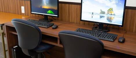 Un espacio de trabajo con dos monitores, dos teclados y dos sillas de oficina.