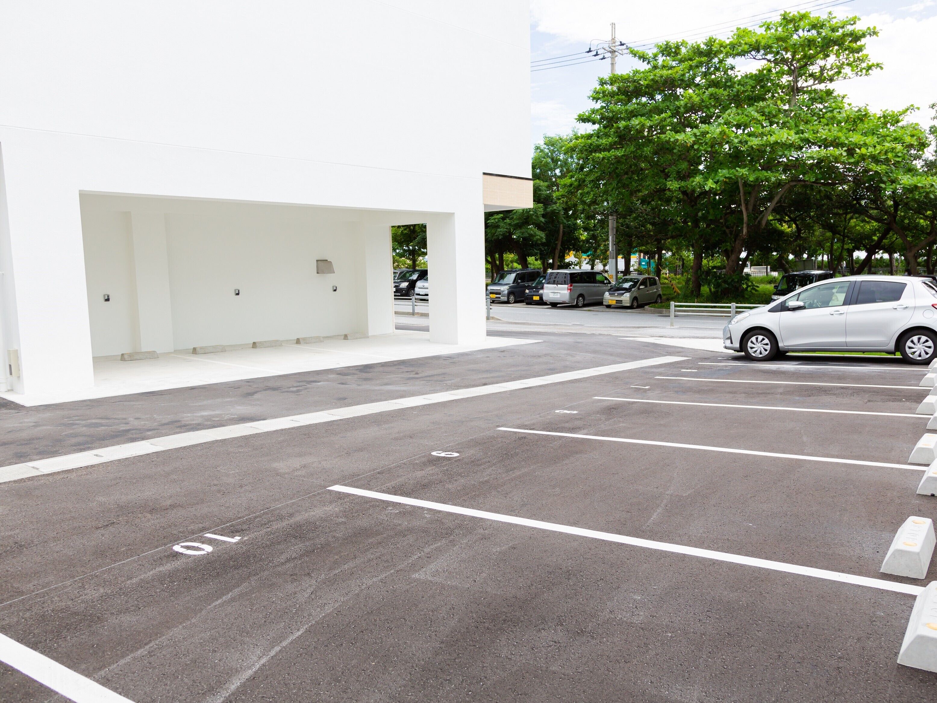 A parking area with marked spaces and a white building in the background.