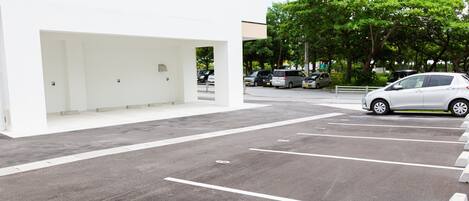 A parking area with marked spaces and a white building in the background.