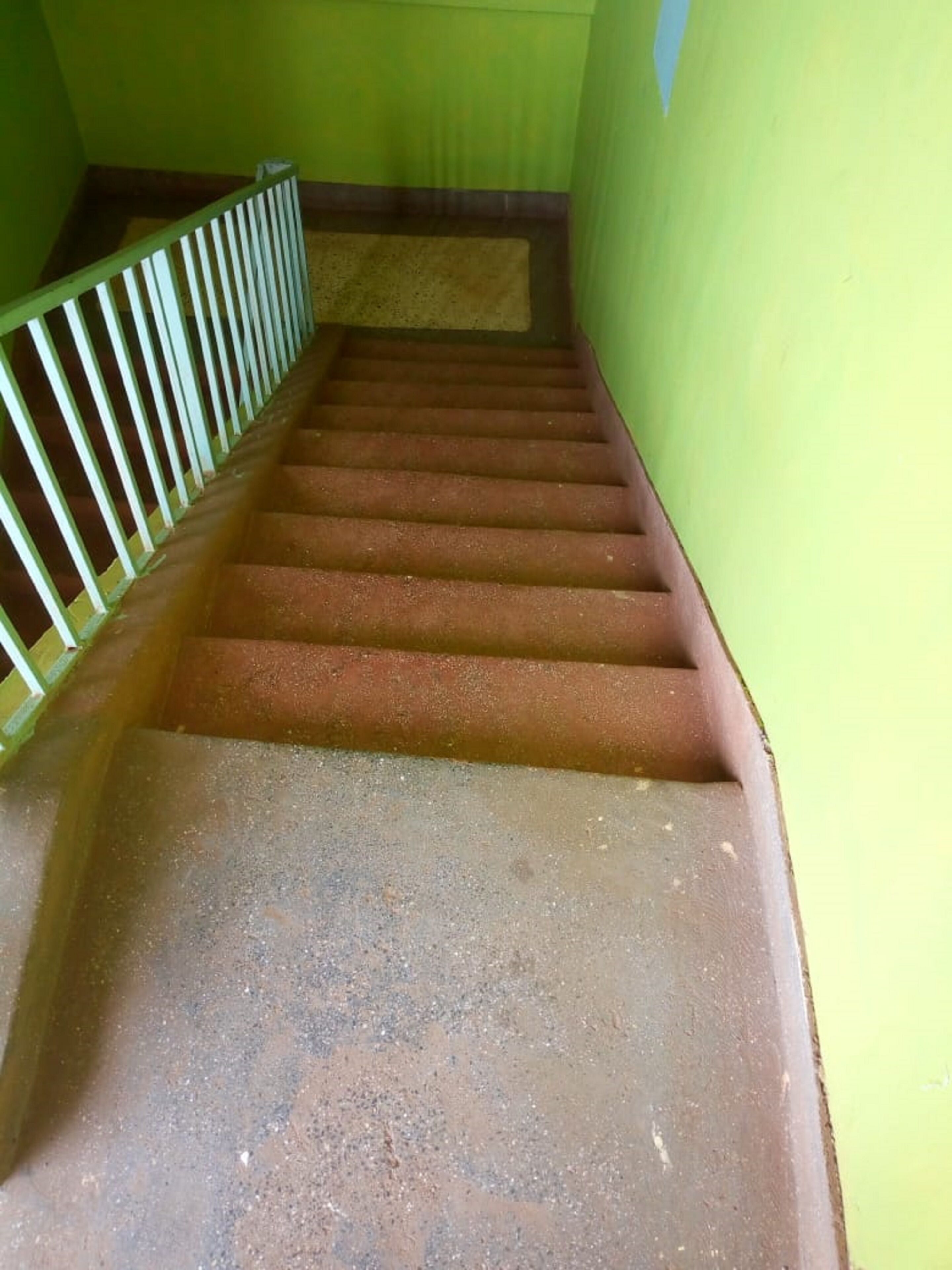 Eine Treppe mit grünen Wänden und einem Metallgeländer.