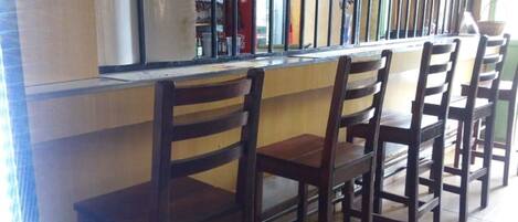 A bar area with wooden chairs and a counter.
