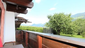 A balcony with a wooden railing overlooking a lush green landscape and mountains. - Beautiful apartment for 2 people with WIFI, TV, balcony, pets allowed and panoramic view (Fügen)