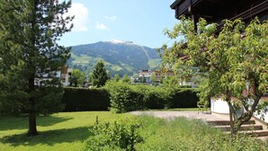 Un quartier résidentiel avec une montagne en arrière-plan, une pelouse bien entretenue et un bâtiment au style architectural traditionnel.