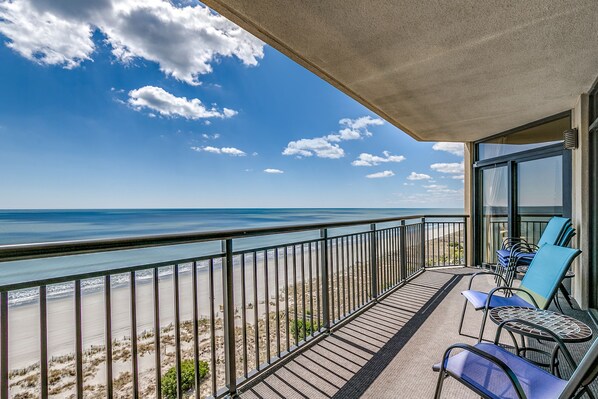 Un balcon avec vue sur la plage et l’océan.