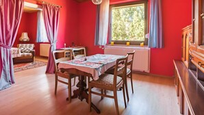 A room with a dining table, chairs, a radiator, a window with curtains, and a ceiling with a grid pattern. - Countryside Stay in Meisdorf (Falkenstein)