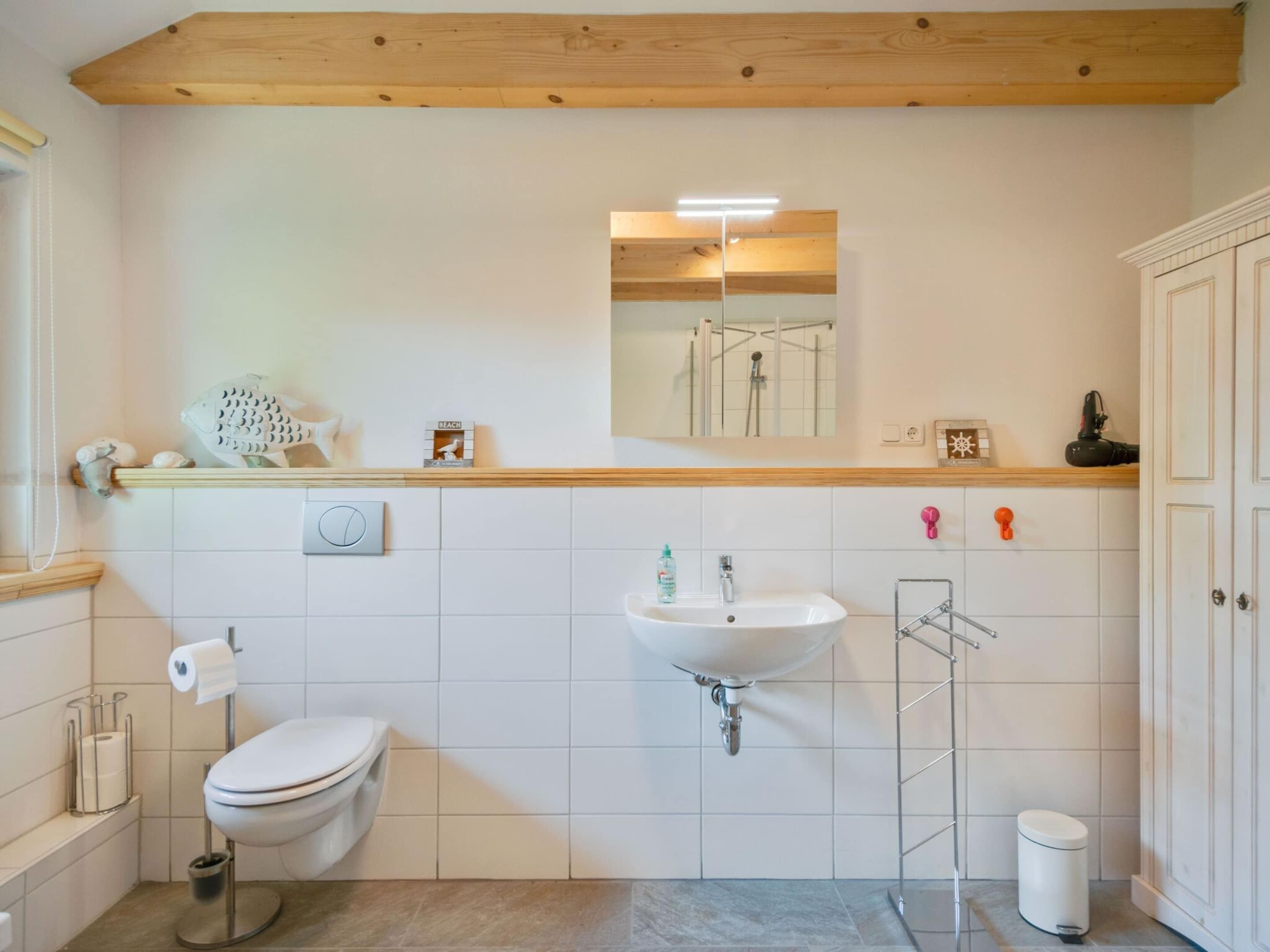 Een badkamer met toilet, wastafel en douche.