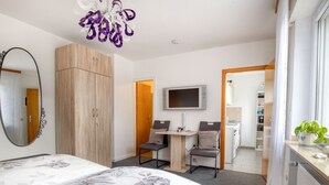 A hotel room with a bed, a desk with a chair, a television, and a wardrobe. - Quaint Holiday Home in Möhnesee near Druggelter Kapelle (Moehnesee)