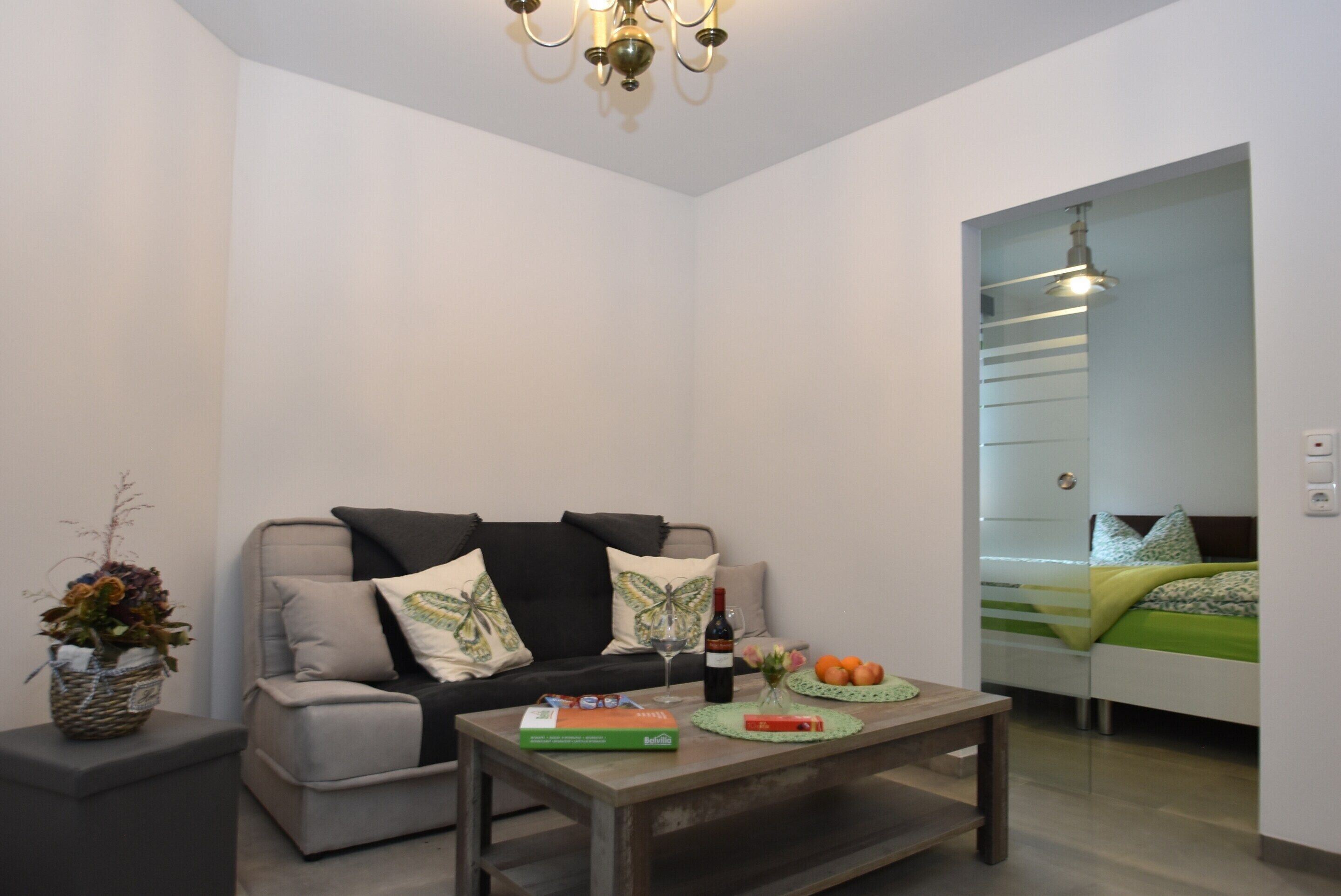 A modern living room with a sofa, coffee table, and a small side table with a vase.