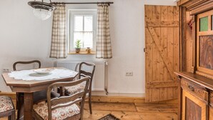 A dining area with a wooden table, chairs, and a hanging light fixture. - Escape Near River, Wolfsberg (Sangerhausen)