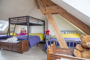 A dormitory room with bunk beds, a wooden desk, a teddy bear, and a lamp. - Renovated Village House With Enclosed Garden (Saint-Louis)