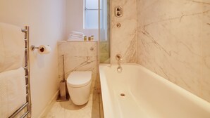 A bathroom with a toilet, a bathtub, and a shower. - Alluring Studio in London near Buckingham Palace (London)