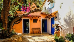 A courtyard with a stone floor, a bench, and potted plants. - Tranquil Holiday Home in Palaiochora near Sea Beach (Kantanos-Selino)