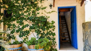 A stone staircase leading to a blue door, surrounded by greenery and wooden planters. - Tranquil Holiday Home in Palaiochora near Sea Beach (Kantanos-Selino)