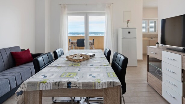 A modern apartment with a dining area, kitchen, and balcony with a view. - Simplistic Apartment in Neviđane with Balcony  (Pasman)