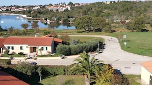 Un quartier résidentiel avec des maisons, une route sinueuse et une étendue d’eau en arrière-plan.