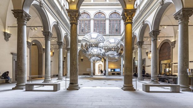 Ein geräumiger Atrium mit klassischer Architektur, gekennzeichnet durch hohe Decken, große Säulen und eine zentrale Kuppel.