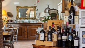 Un coin bar avec des caisses en bois remplies de bouteilles de vin, une lampe et un miroir en arrière-plan.